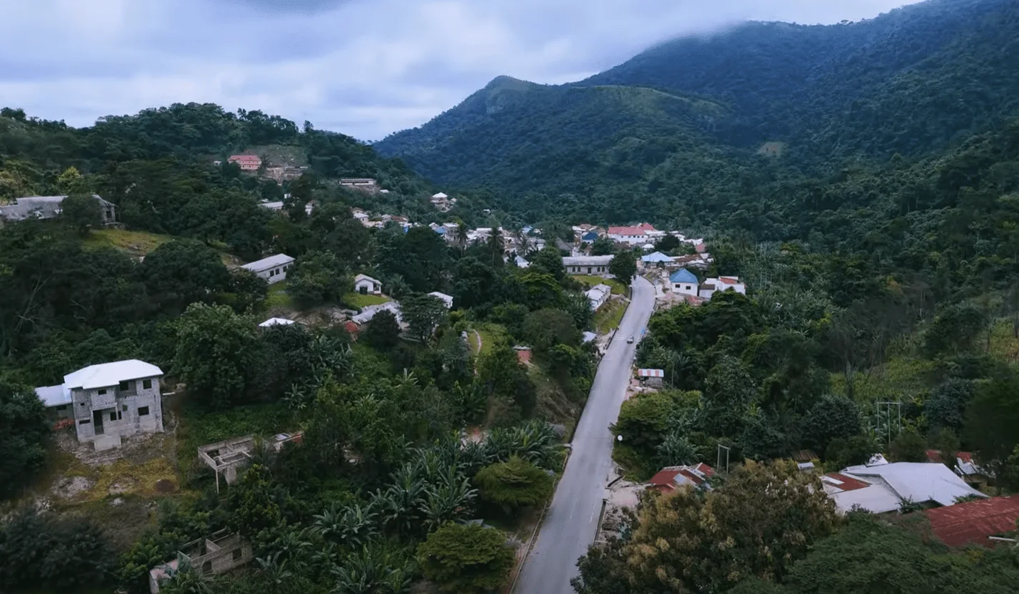 A village road surrounded by green mountains and forest